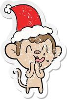 crazy distressed sticker cartoon of a monkey wearing santa hat vector