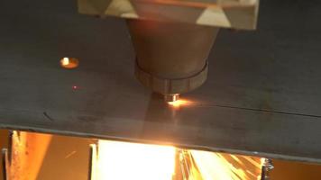 máquina de corte a laser cnc. a folha de metal é cortada na máquina cnc e os furos são feitos nela. dispositivo de corte a laser seguindo luz laser e luz laser. corte de peças metálicas industriais. video