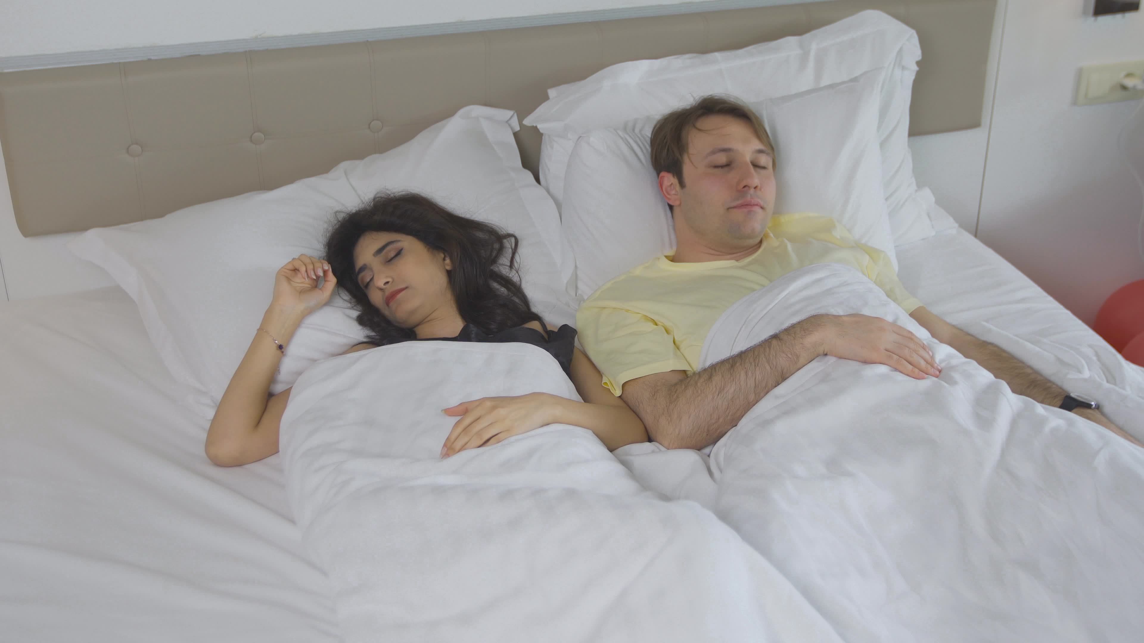 Woman waking up and getting out of bed. The woman sleeping with her husband  wakes up with a yawn and gets out of bed. 8782580 Stock Video at Vecteezy