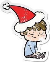 distressed sticker cartoon of a happy boy wearing santa hat vector