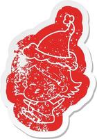 cartoon distressed sticker of a woman sitting wearing santa hat vector