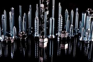 A fantastic city made of bolts, nuts, screws and self-cuts on a black background with reflection photo