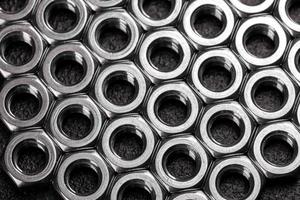 Metal steel nuts laid in composition on a dark table photo