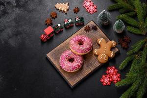 A beautiful doughnut with pink glaze and colored sprinkle on a christmas table photo