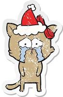 distressed sticker cartoon of a cat wearing santa hat vector