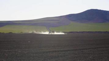 fumigación agrícola agroquímica del tractor. tractor está haciendo fumigación agrícola en tierras agrícolas. tierra del suelo al atardecer.