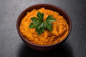 Squash caviar with garlic and tomatoes in a rustic bowl on a dark background photo