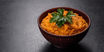 Squash caviar with garlic and tomatoes in a rustic bowl on a dark background photo