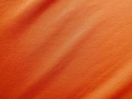 textura de jersey de tela de ropa deportiva naranja foto
