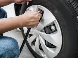 man filling air pressure in the car tyre photo