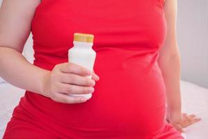 Pregnant woman holding milk bottle photo