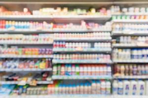 Abstract blur supermarket grocery store refrigerator shelves with fresh milk bottles and dairy products photo