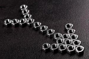 Metal steel nuts laid in composition on a dark table photo