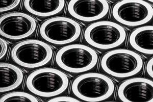 Metal steel nuts laid in composition on a dark table photo