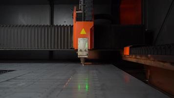 industrielle CNC-Laserschneidmaschine. Auf einer CNC-Laserschneidmaschine wird ein Blech geschnitten. Löcher öffnen sich und Funken kommen heraus. Industrie. video