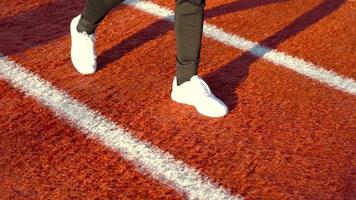 pies de hombre caminando en la pista de atletismo. los pies del hombre que camina. deporte y actividad. video