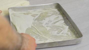 bakalava desserttillverkning. baklavabakelse läggs på brickan. video
