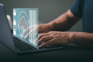 man using the laptop computer to store important data through a cloud system photo