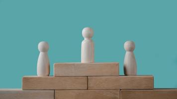 Wooden dolls placed on wooden blocks are a Successful business team leader concept. photo