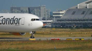 frankfurt am main, duitsland 18 juli 2017 - condor airlines boeing 767 taxiënd voor vertrek. grijze reiger die door het gras op de voorgrond schrijdt video