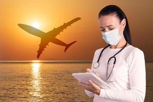 Medical tourism business, health insurance. Doctor in a medical mask against the backdrop of a plane taking off. photo