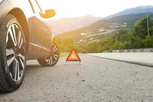 An emergency stop sign of a vehicle is installed on the road, next to the car. Copy space. photo