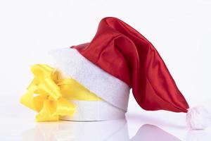 regalo en forma de rollo de papel higiénico con un lazo amarillo, bajo el sombrero de santa claus. copie el espacio foto