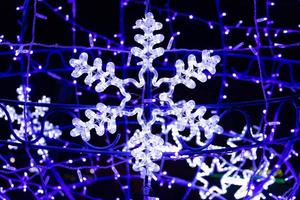 Beautiful christmas decoration on the streets of Europe, bright glowing neon snowflake photo