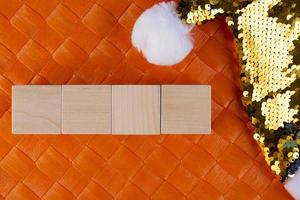 Concept for writing text from four letters or numbers on wooden cubes lying on an orange surface and with a Santa Claus hat. Copy space. photo
