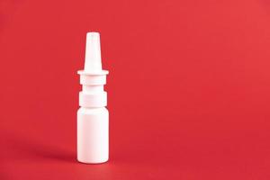 Medicinal nasal spray, on a red background. Copy space. photo