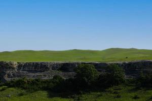 A picturesque view of the green steppe hills, pastures stretching into the distance. photo