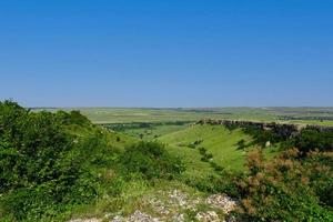 A picturesque view of the green steppe hills, pastures stretching into the distance. photo