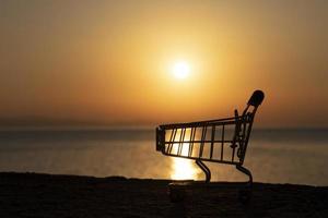 Shopping cart against the background of the rising, setting sun. photo