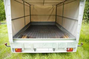 Two-axle car trailer with cargo, metal, reinforced mesh for construction. Selective focus. photo