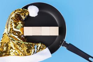 The concept of writing text on four wooden cubes that lie in the pan and hat of Santa Claus. Copy space. photo