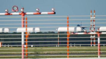 avion commercial atterrissant à l'aéroport un jour d'été. vue à travers l'atterrissage et les feux de signalisation sur l'aérodrome video