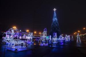 árbol de navidad, árbol de año nuevo afuera en la noche bajo la nieve. foto