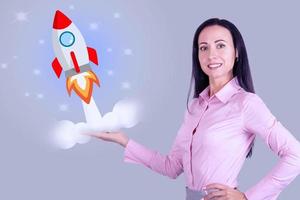 Startup concept. Business woman launches a rocket. photo