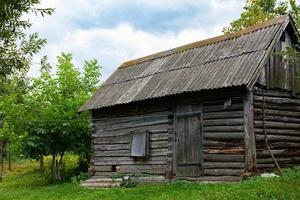 An old wooden bathhouse, a house on a green lawn. photo