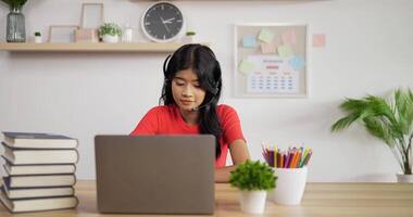 Portrait of Asian schoolgirl studying online via laptop at home. Distance learning and education concept. video