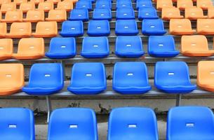 plástico, amarillo y azul, sillas nuevas en el estadio. foto