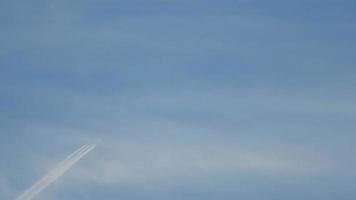 Contrails in the blue sky. Airplane flying high. Slow motion video