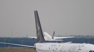 frankfurt am main, duitsland 17 juli 2017 - lufthansa airbus 340 d aiff, star Alliance livery slepen van service en lufthansa airbus 380 opstijgen om 25c. fraport, frankfurt, duitsland video