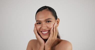 portrait de visage de femme asiatique heureuse regardant la caméra. beau modèle féminin avec une peau fraîche parfaite et propre. traitement de soins de la peau ou concept d'annonces cosmétiques. video