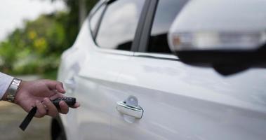Man hand using remote key. Locking the car by the car key remote control. Pressing the button of the car key and the lights blink when door open or closed.