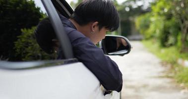asiatischer automechaniker, der auf dem fahrersitz sitzt und auf die straße blickt. Service-Wartungsversicherung mit Automotor. Auto-Service-Konzept. video