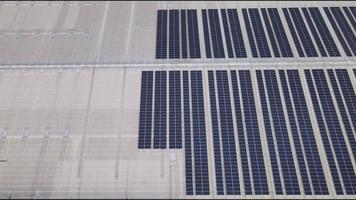 imagen aérea de drones de paneles solares instalados en el techo de un gran edificio industrial o almacén. edificios industriales.la energía renovable fuentes sostenibles energía verde fotovoltaica. video