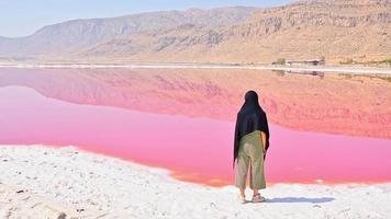 kaukasischer frauentouristenstand auf maharlu-rosa salzseeufer. reiseziel iran in shiraz video