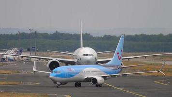 FRANKFURT AM MAIN, GERMANY JULY 20, 2017 - TUIfly Boeing 737 D ATUR taxiinf after landing and Cathay Pacific Boeing 777 towing from service. Fraport, Frankfurt, Germany video