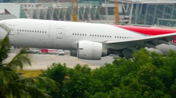 PHUKET, THAILAND DECEMBER 1, 2016 - Footage of Boeing 777 Nordwind Airways landing, touching the runway and braking with smoke at Phuket airport -HKT-. Tourism and travel concept video